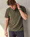 Man wearing olive green short sleeve t-shirt in a studio