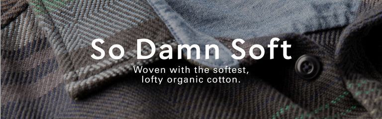 Text 'So Damn Soft' on a textured fabric background with organic cotton information.