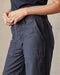 Person wearing dark blue cargo pants on a neutral background