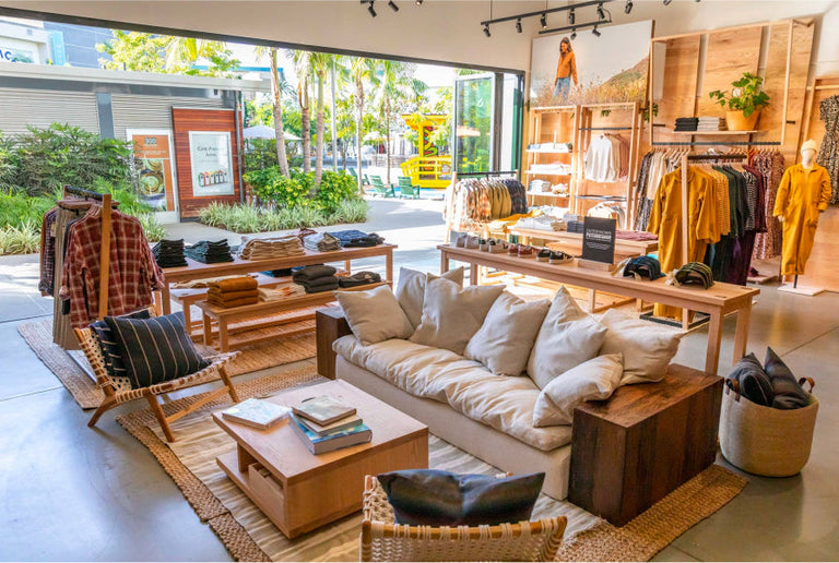 image of the interior of an outerknown store with clothing racks and a sitting area.